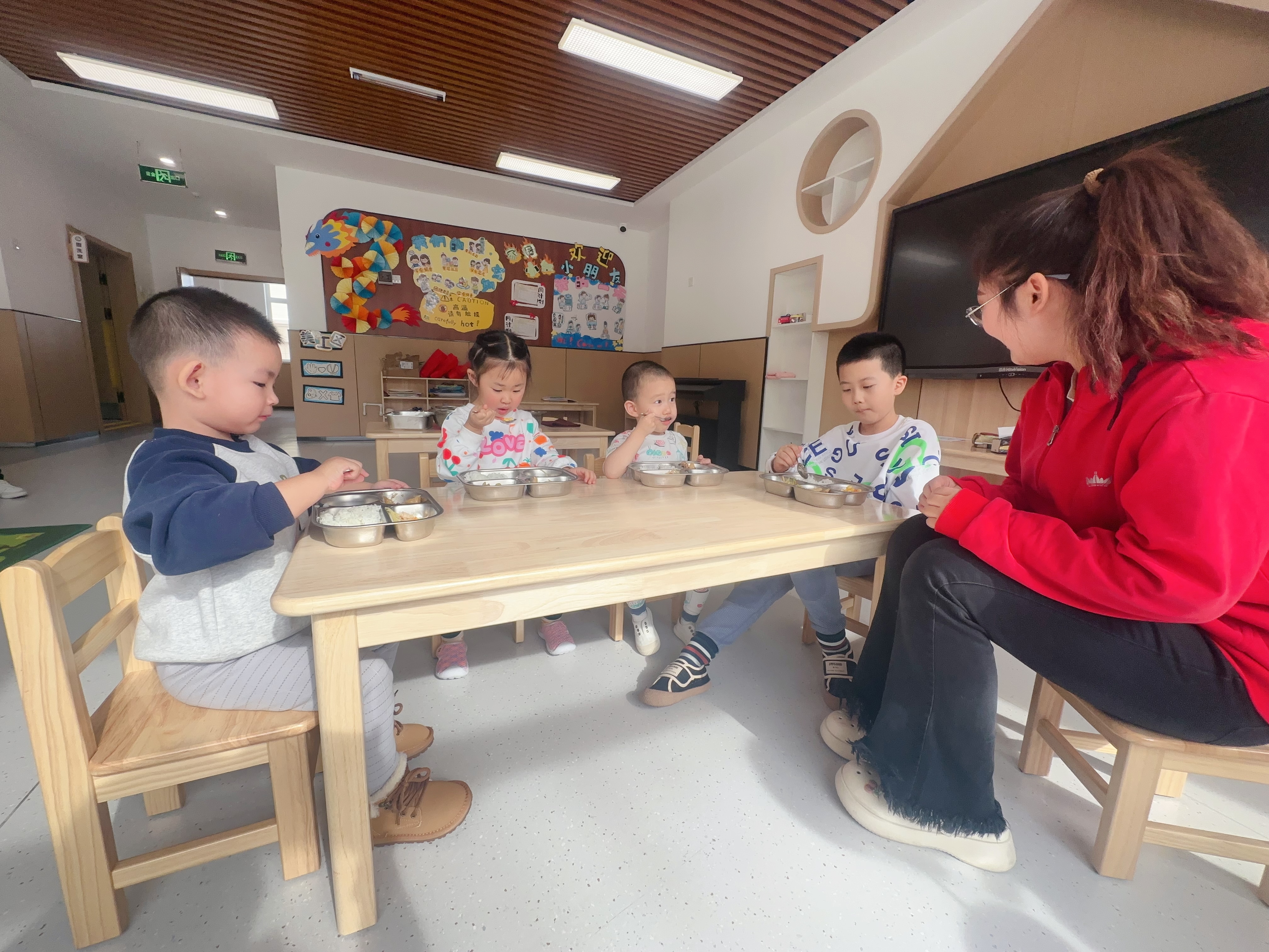 綠園區(qū)第四實(shí)驗(yàn)幼兒園，孩子在開心地吃著園區(qū)精心搭配的營養(yǎng)午餐（綠園區(qū)教育局供圖）.jpg