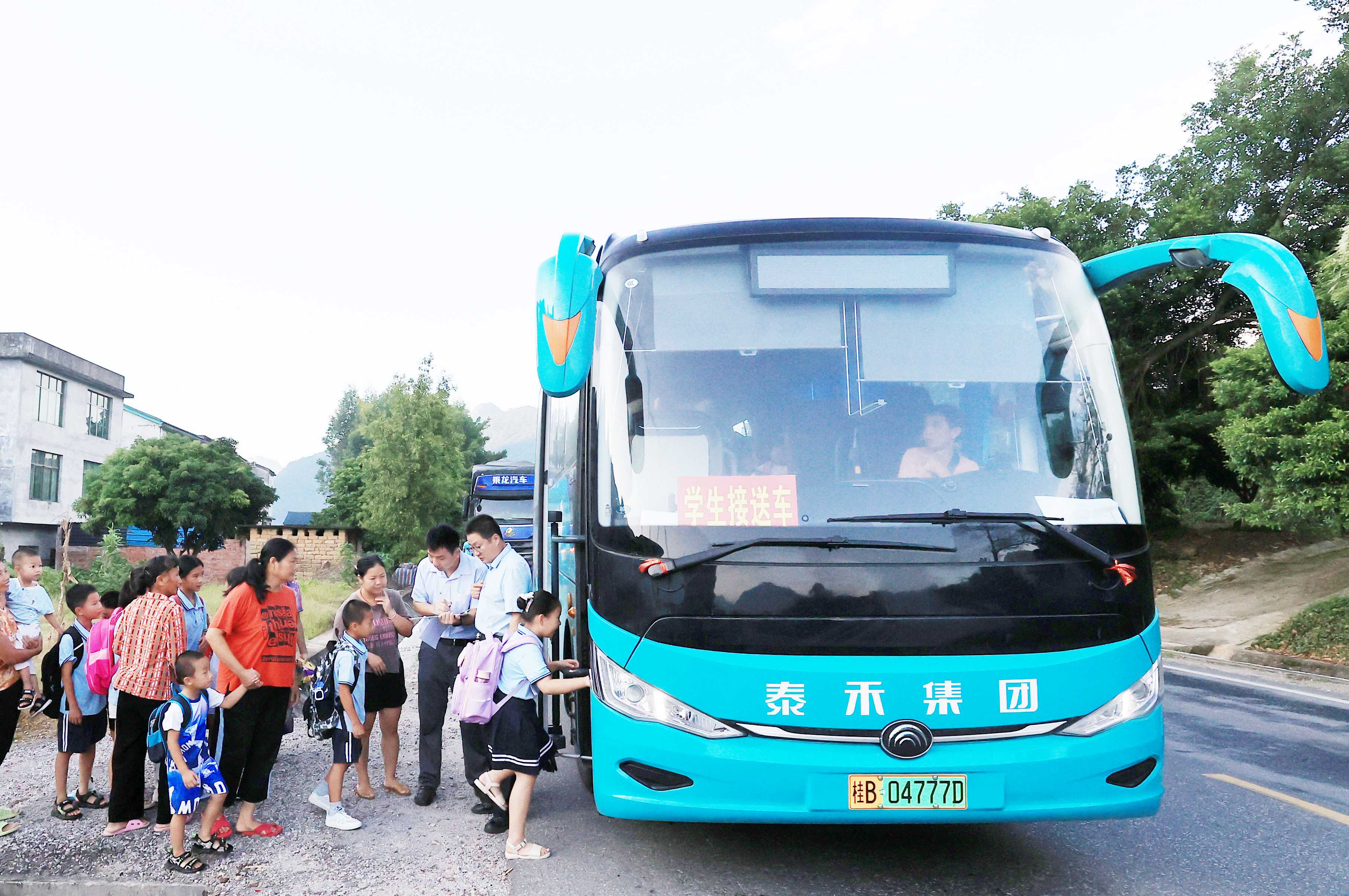 圖2：9月2日早晨，在廣西柳州市融安縣浮石鎮(zhèn)諫村村，工作人員在核對(duì)乘車人員名單，準(zhǔn)備送學(xué)生去學(xué)校讀書(shū)。（譚凱興 攝）.JPG