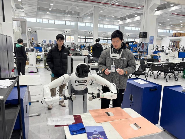 浙江工商職業(yè)技術(shù)學院“普智未來”訂單班學生在調(diào)試機器人 學校供圖.png